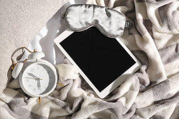 Sleeping mask, alarm clock and tablet computer on fluffy blanket