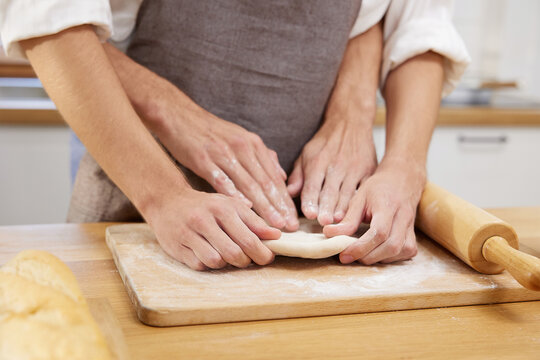 close up gay couple hands making a bread together in the kitchen