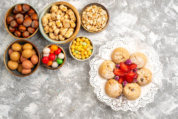 top view hazelnuts and peanuts with candies and cookies on white background nut hazelnut walnut snack candy