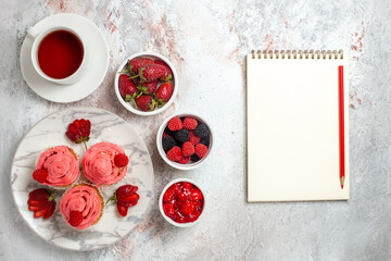 Obraz na płótnie Canvas top view pink strawberry cakes with cup of tea on a white background fruit sugar berry cake biscuit sweet