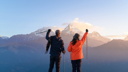 A young couple travellers trekking in Poon Hill view point in Ghorepani, Nepal.
