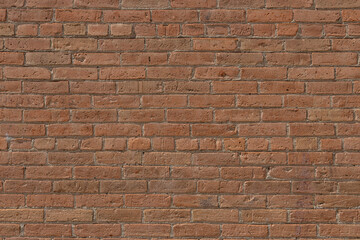 Abstract texture background of an antique reddish brown exterior clay brick wall with weathered bricks showing wear from age