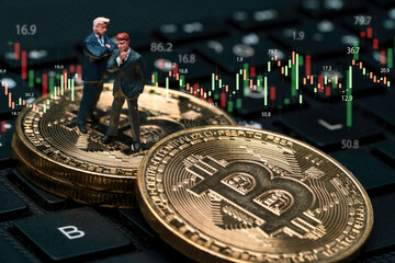 Miniature figure of businessmen standing on golden bitcoin and computer keyboard with stock market graph chart for cryptocurrency investment trading concept