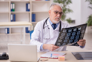 Old male doctor radiologist working in the clinic