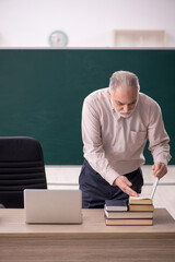 Old male teacher in the classroom