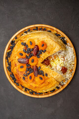 Obraz na płótnie Canvas top view tasty shakh plov with raisins and dried apricots on dark background meal cooking rice dough food