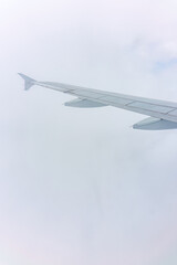 View from the airplane window at a beautiful cloudy sky and the airplane wing