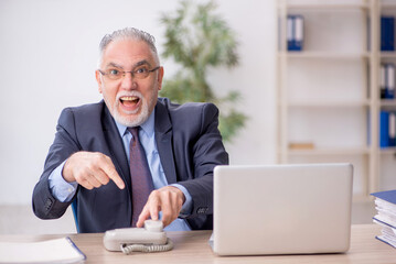 Old male employee working in the office