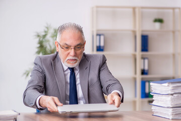 Old male employee working in the office
