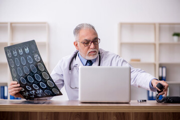 Old male doctor radiologist working in the clinic