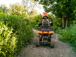 Obraz premium A child rides a quad bike through the mud. ATV rider rides