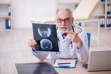 Old male doctor radiologist working in the clinic
