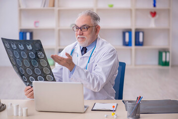 Old male doctor radiologist working in the clinic