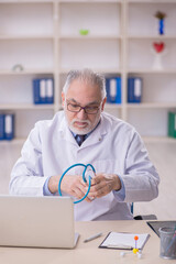 Old male doctor working in the clinic