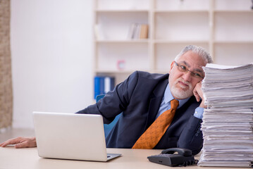 Old male employee unhappy with excessive work in the office