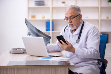 Old male doctor radiologist working in the clinic