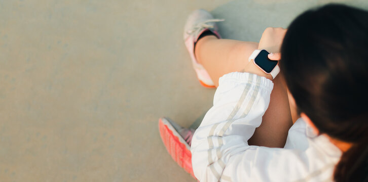 Smart watch on woman's hand outdoor, Hand touching a smartwatch measure his heart rate while walking or preparing for outdoor running training. Female's hand uses of wearable smart watch at outdoor.