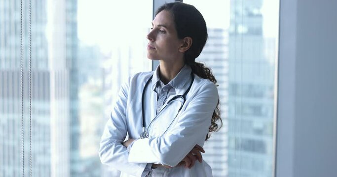 Serious concerned woman therapist standing alone in modern office look disappointed due to professional failure, unsuccessful in work, medical mistake, feel frustrated and upset, search issue solution