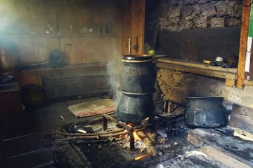 Papier Peint photo Manaslu In a Nepalese Himalayan village kitchen along the Manaslu Circuit, a Rakshi distillation waterpot boils water, infusing the air with a sense of tradition and warmth.