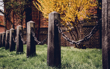 Old stone posts with chains on a background of green grass