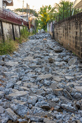 A background view of a smashed concrete road lined with rubble.