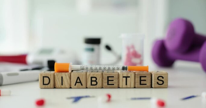 Word diabetes with insulin syringe lancet and pills on table in clinic. Insulin in treatment of diabetes
