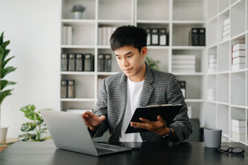 Fototapeta premium Asian business man executive manager looking at laptop watching online webinar training or having virtual meeting video conference doing market research working in modern office.