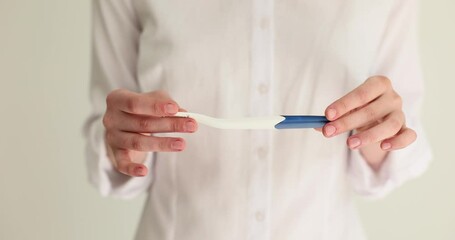 Young woman holds positive or negative pregnancy test result in hands. Treatment of female infertility and concept of in vitro fertilization