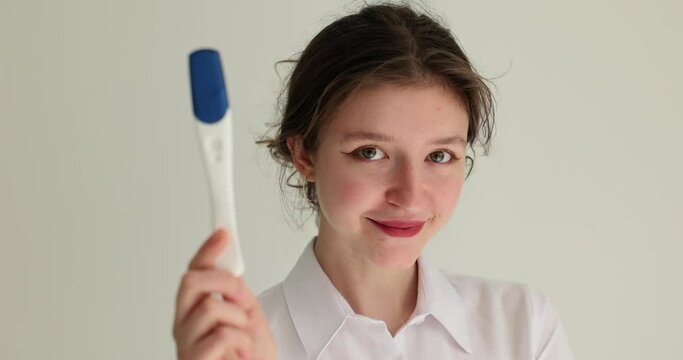 Young happy woman holding pregnancy tests. Negative pregnancy test