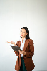 Portrait photo of young beautiful Asian woman feeling happy and holding smart phone, tablet and laptop with black empty screen on white background product presenting concept..