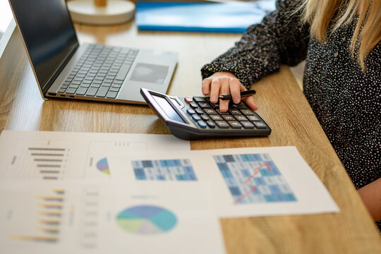 Doradca finansowy obliczający koszty inwestycji siedząc przy biurku 