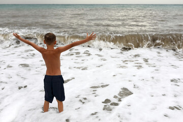 Child on shore of stormy Black Sea