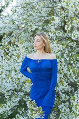 Femininity concept, tender modern European lady in blue dress at evening garden