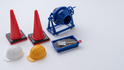 ミニチュアのコンクリートミキサーと三角コーン・建設工事イメージ