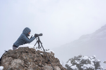 snowy day with this horizontal shot featuring a woman taking photographs, providing ample copy space for your winter-themed content