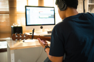 Asian man making music at home studio