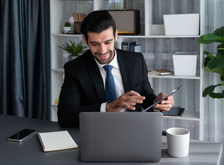 Professional businessman in black suit, present financial data or BI paper via laptop during online...