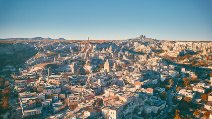 Goreme village in sunny afternoon and Uchisar Castle rock on the horizon. Autumn in Cappadocia,...