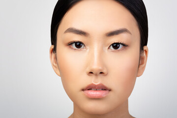 Closeup Of Asian Woman's Face With Makeup Over Gray Background