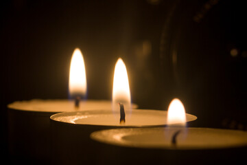 Tres mini velas de te con llama en bokeh y fondo tétrico - obrazy, fototapety, plakaty
