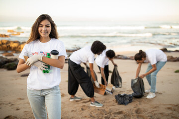 Smiling young multiethnic people volunteers in t-shirts with garbage bags clean up garbage