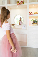 Teen girl in tutu-skirt and high-heeled shoes making selfie on smartphone