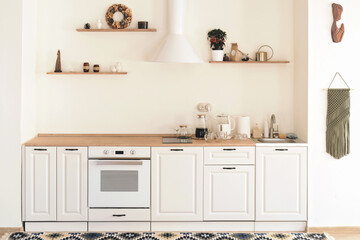 Fototapeta na wymiar modern trendy white kitchen with boho decor. light and airy country kitchen, neat and clean stylish home. 