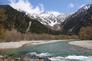 The clear Azusa River and snow-capped Mount Hotaka viewed from Kamikochi in Japan