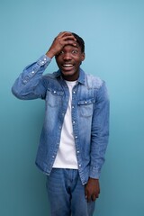 vertical portrait of handsome young stylish african man with curls in denim clothes