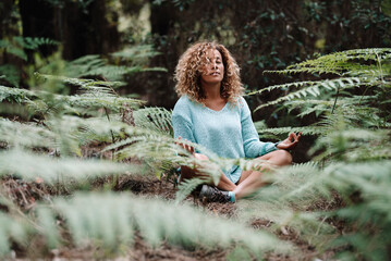Health natural lifestyle meditation woman in the forest park with green tropical leaves all around....