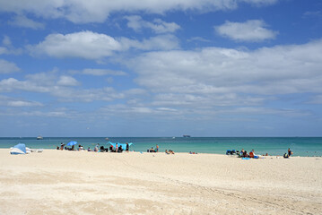 Fototapeta na wymiar Paradise. Sunny sandy beach with sun loungers and umbrellas at South Pointe. Miami Beach, Florida