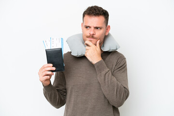 Young caucasian man holding a passport isolated on white background having doubts and thinking