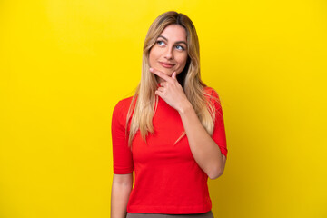 Young Uruguayan woman isolated on yellow background having doubts and with confuse face expression