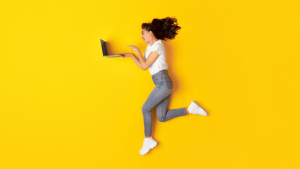 Excited Lady Using Laptop Running Browsing Internet On Yellow Background